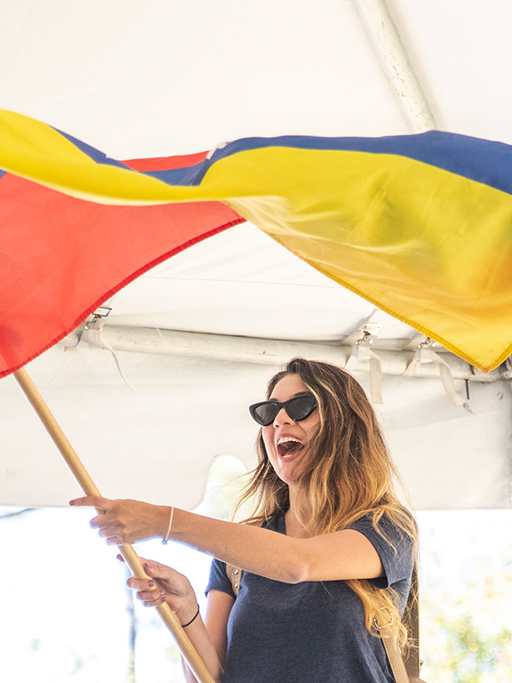 Student waving a Venezuelan flag at the annual UWF Global Block Party event.