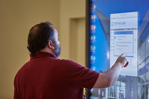 Business student working on a large touchscreen display.