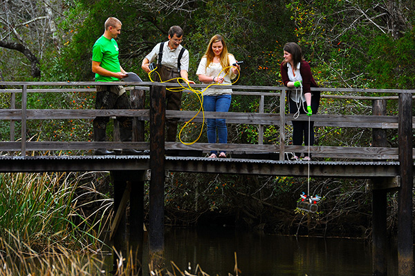dr johan liebens and environmental science students taking water samples