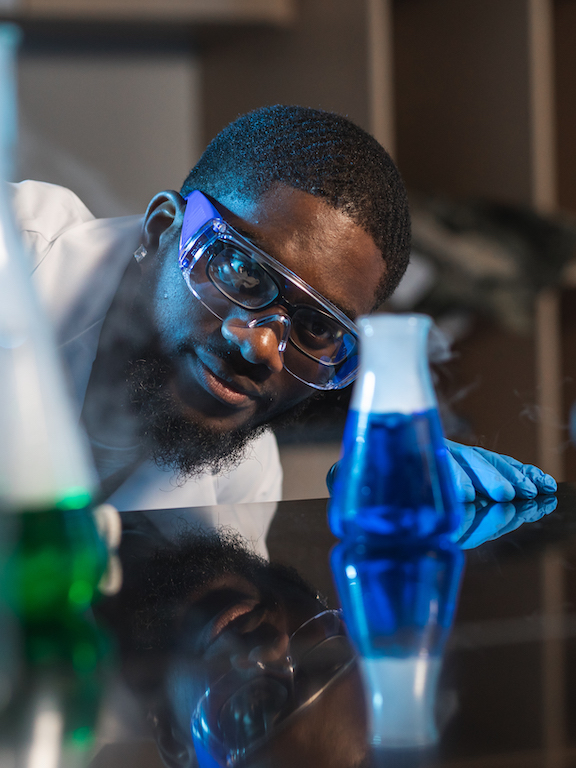 chemistry student examining flasks