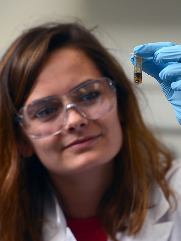 Environmental Student holding a small beaker