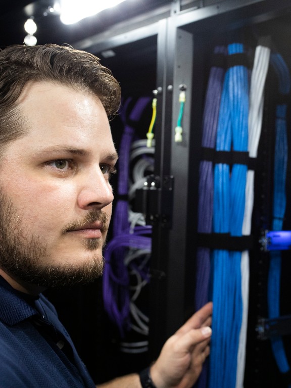 worker examining a server stack	