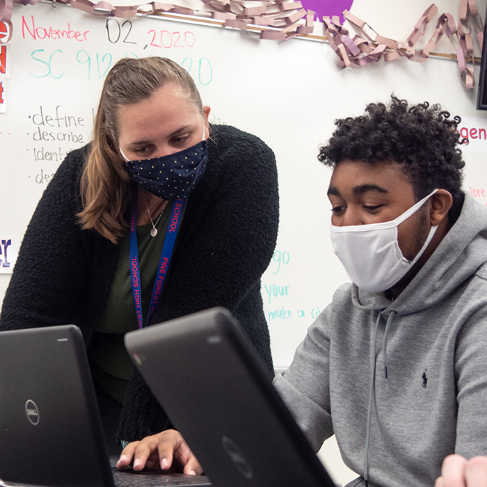 Teacher helping a student do online work