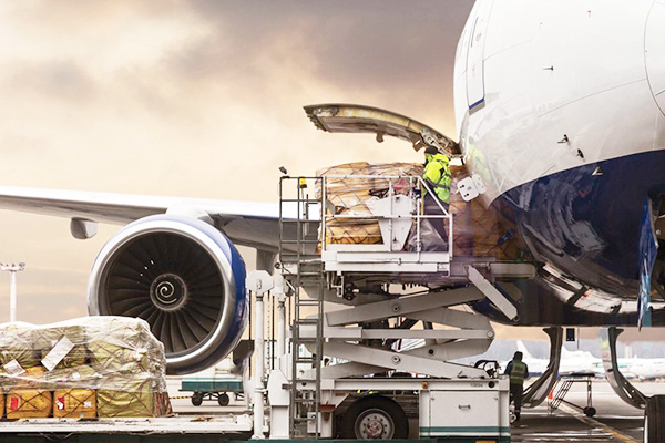 workers in yellow safety vest preparing to load an aircraft