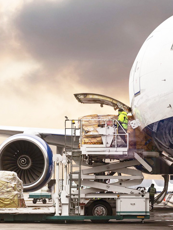 workers in yellow safety vest preparing to load an aircraft