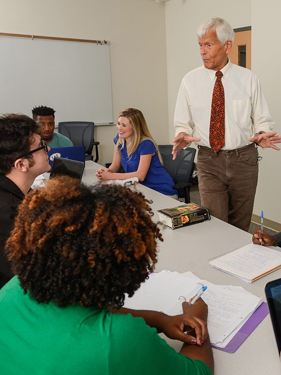professor discusses free market economies with students