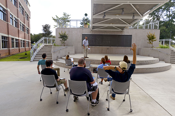 mathematics students studying on a blackboard outside of building 4