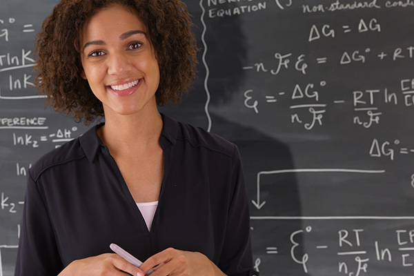 mathematics faculty in front of a chalk board covered in equations