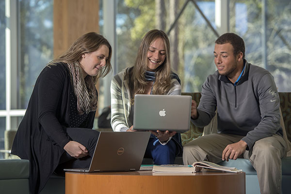 Three mba students studying in the Building 76A atrium on the UWF Pensacola campus.
