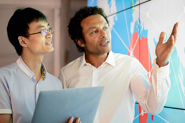 gis student and faculty examining a wall map