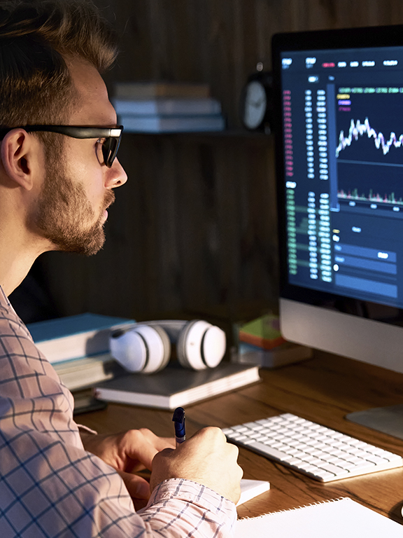 Business trader analyst looking at computer monitor, investor broker analyzing indexes, financial chart trading online investment data