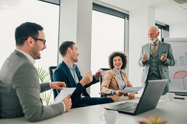 Four behavior analysts laughing during a meeting at a table.