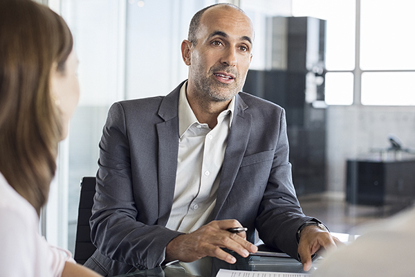 Financial agent in professional attire meeting with two people.
