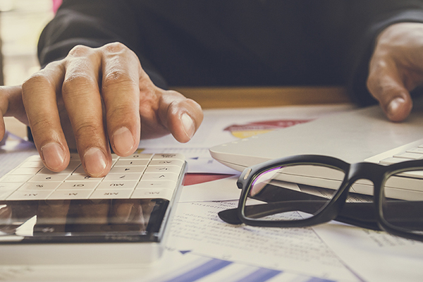 Accountant using a calculator and laptop.