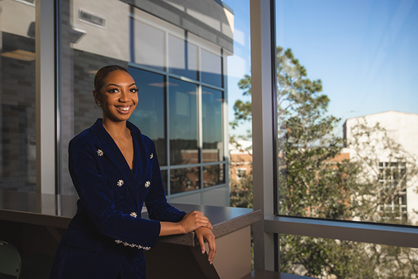 UWF MBA student smiling at camera while standing in front a window.