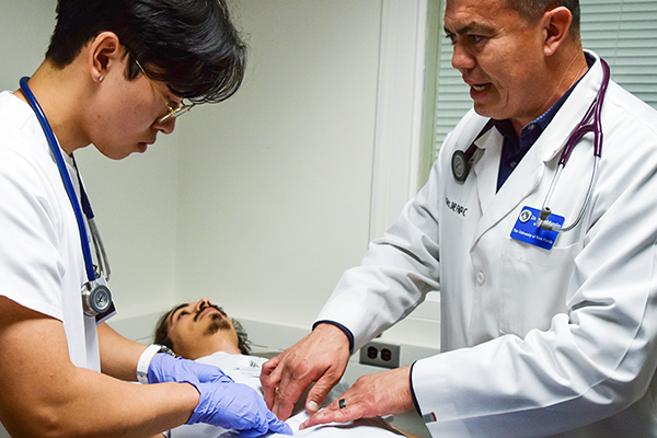 Nursing professor with student and patient.