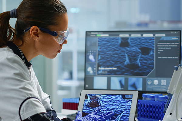 Scientist using a digital tablet analyzing virus evolution, treatment development in medical research laboratory.
