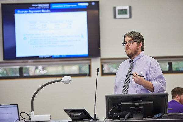 political science faculty giving a class lecture at a podium