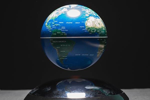 Magnetic levitating globe of Earth showcasing the Atlantic Ocean and surrounding continents of North America, South America, Europe and Africa.
