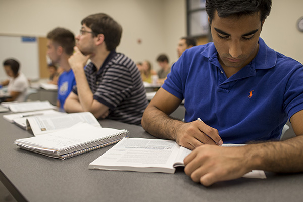 writing student taking notes in class
