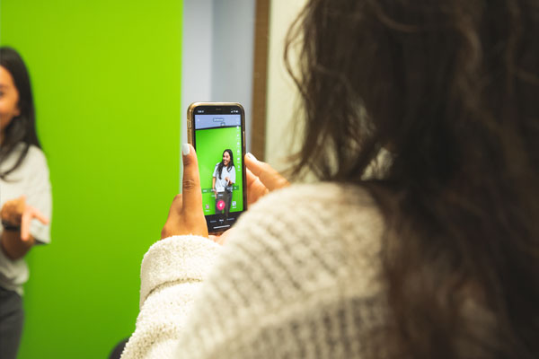 Using a smartphone to video a student against a greenscreen