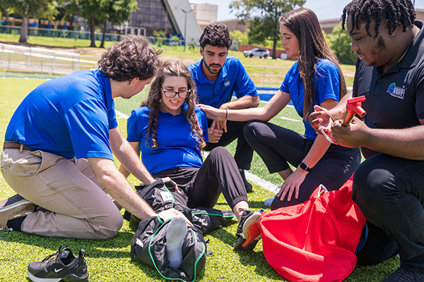 UWF students demonstrating athletic training procedures on PenAir Field on the UWF Pensacola campus.