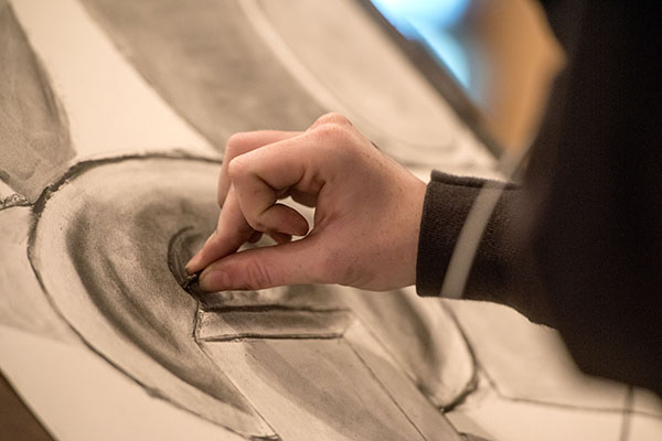 A hand drawing on a canvas with charcoal.