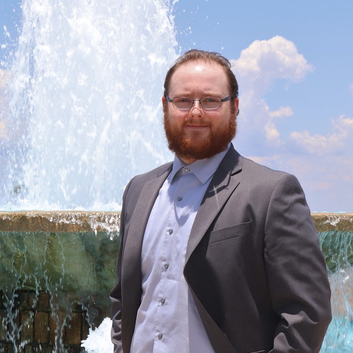 Ty Faist standing in front of a water fountain.