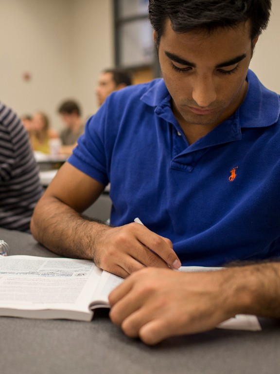 writing student taking notes in class	
