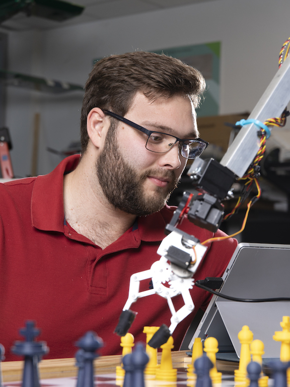 Engineering student working with a robotic arm.