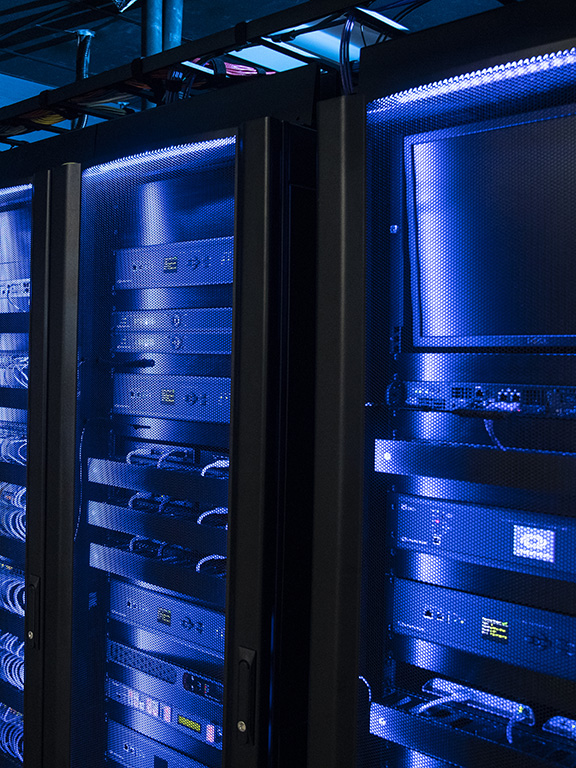 A row of server cabinets containing various computing and cybersecurity equipment.