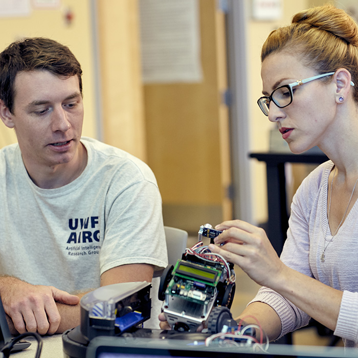 Two Ph.D. students working on a robot.