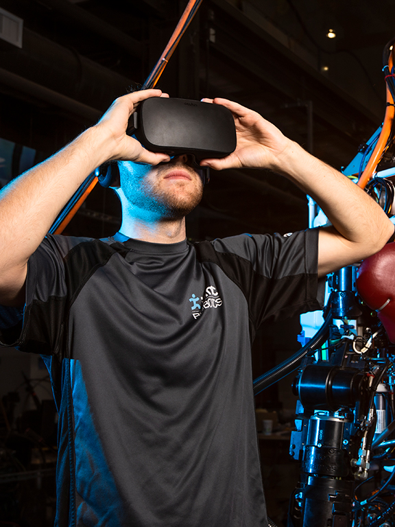 UWF robotics student tests a robot using a virtual reality headset.