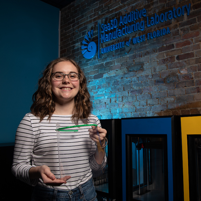 a student holding a 3D printed face shield