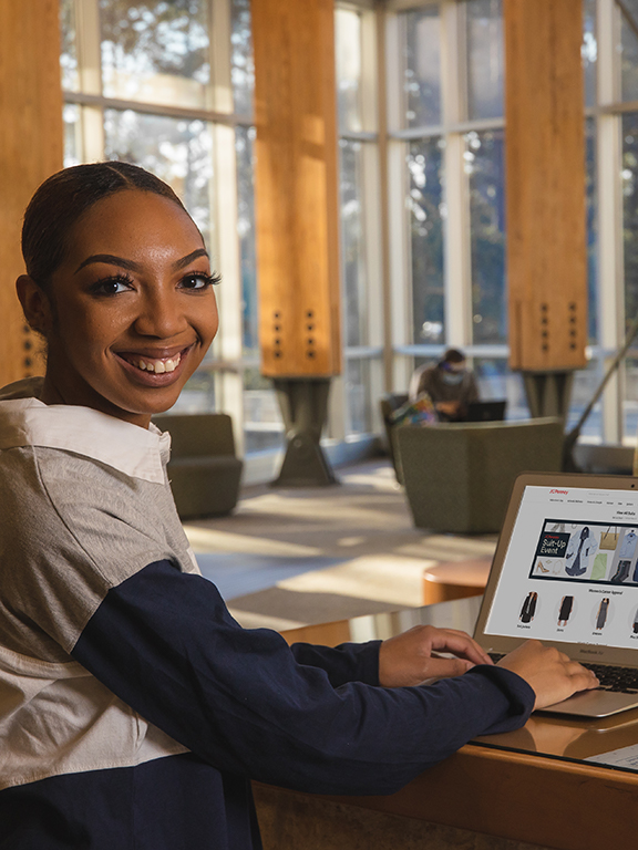 Digital Marketing student sitting in front of a laptop	