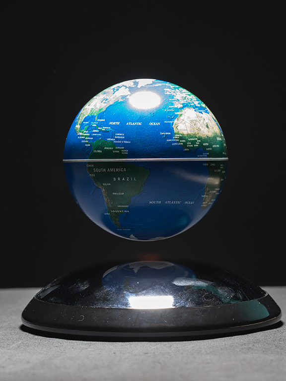 Magnetic levitating globe of Earth showcasing the Atlantic Ocean and surrounding continents of North America, South America, Europe and Africa.