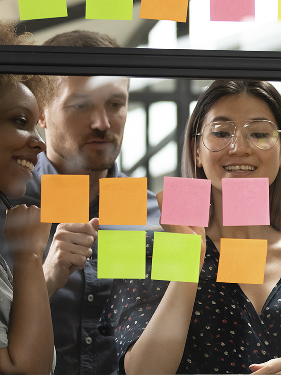 Team reviewing organizational development with notes on window