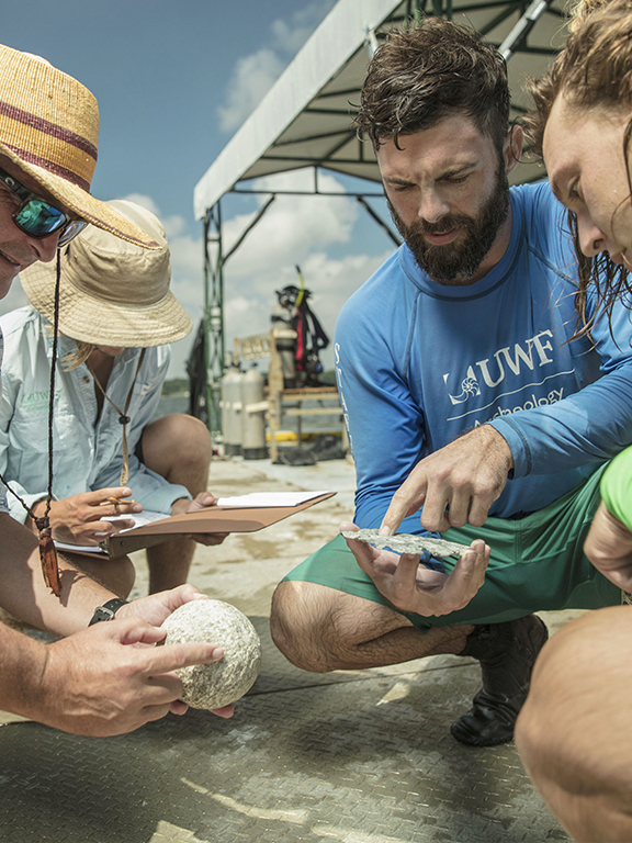 Maritime studies students holding shells during field work.