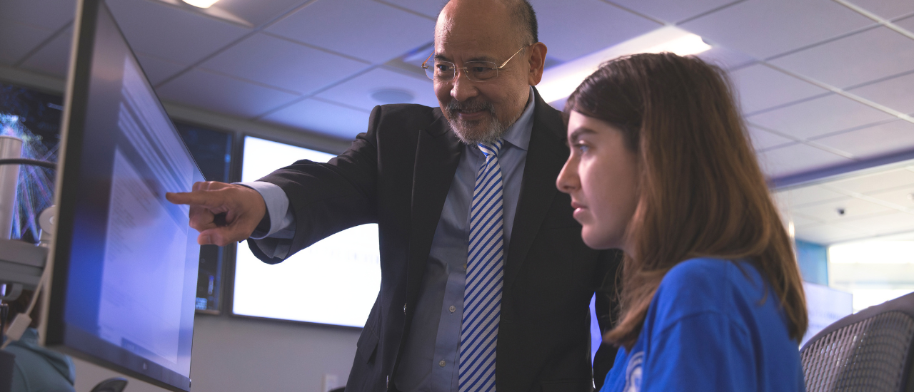 Faculty member helping a student on the computer