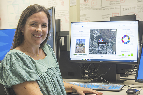 GIS professional at a computer showcasing a GIS project on the screen.