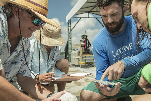 Maritime studies students holding shells during field work.