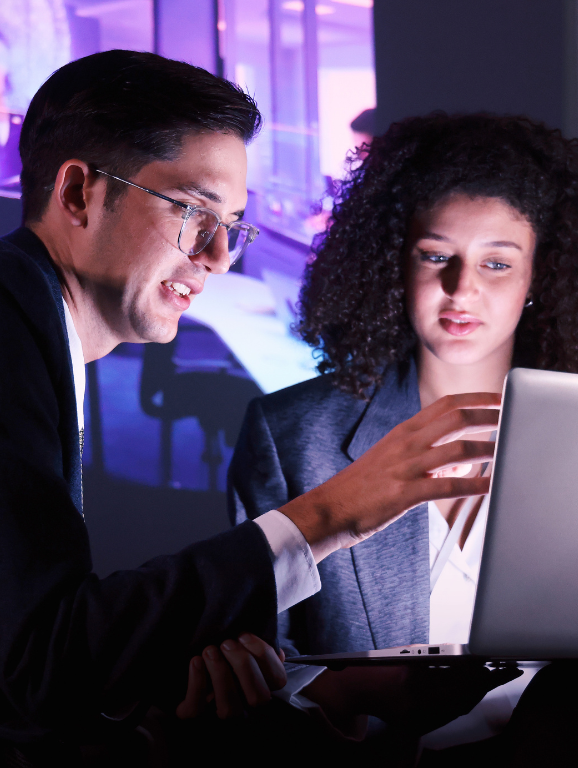 Two individuals collaborating on a laptop