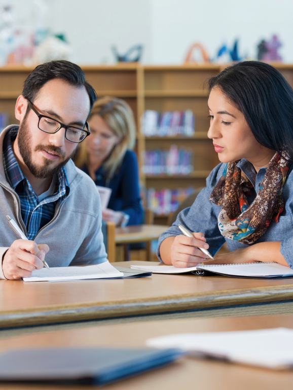 Two students working together in a library