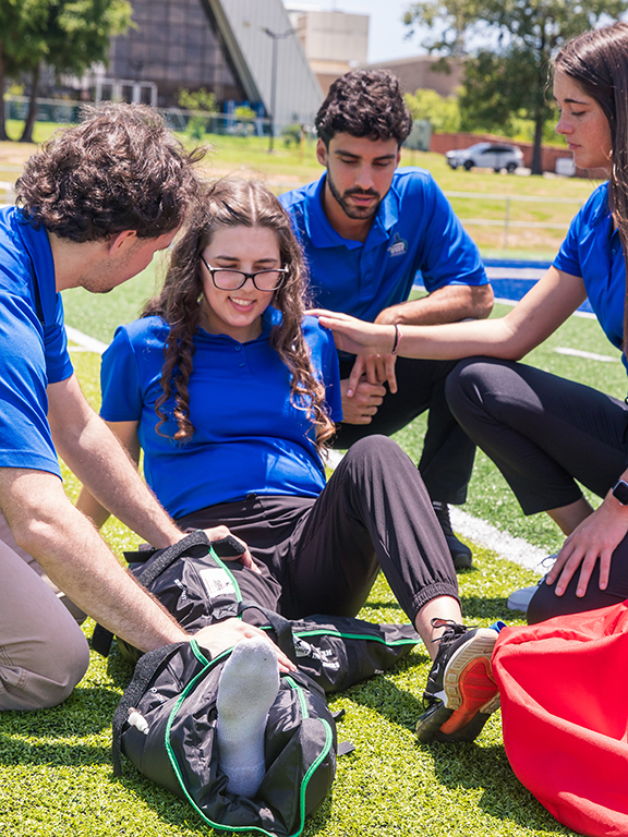 UWF students demonstrating athletic training procedures on PenAir Field on the UWF Pensacola campus.