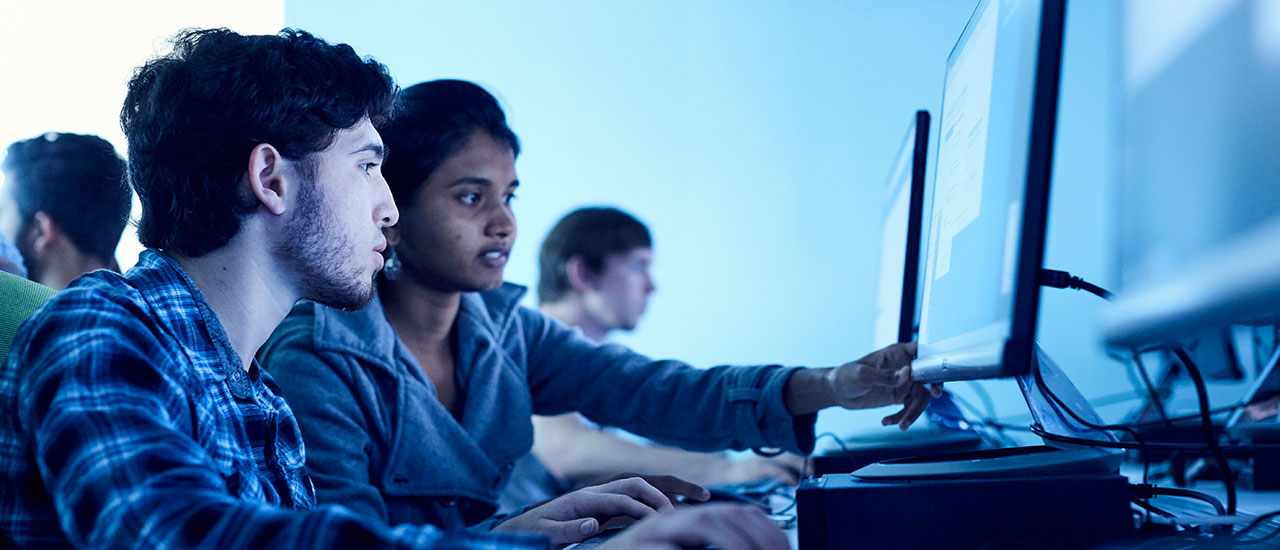 two cybersecurity students working in a computer lab