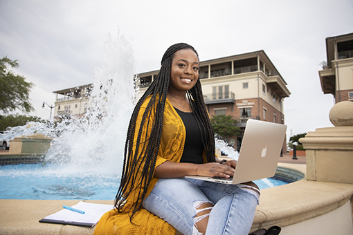 student studying on a laptop on uwf's pensacola campus