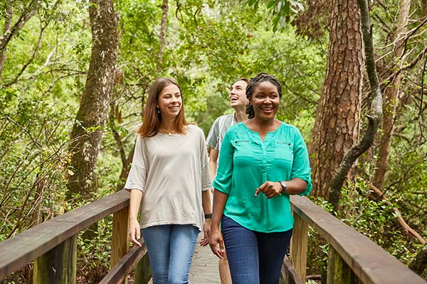 three students walking on a nature trail