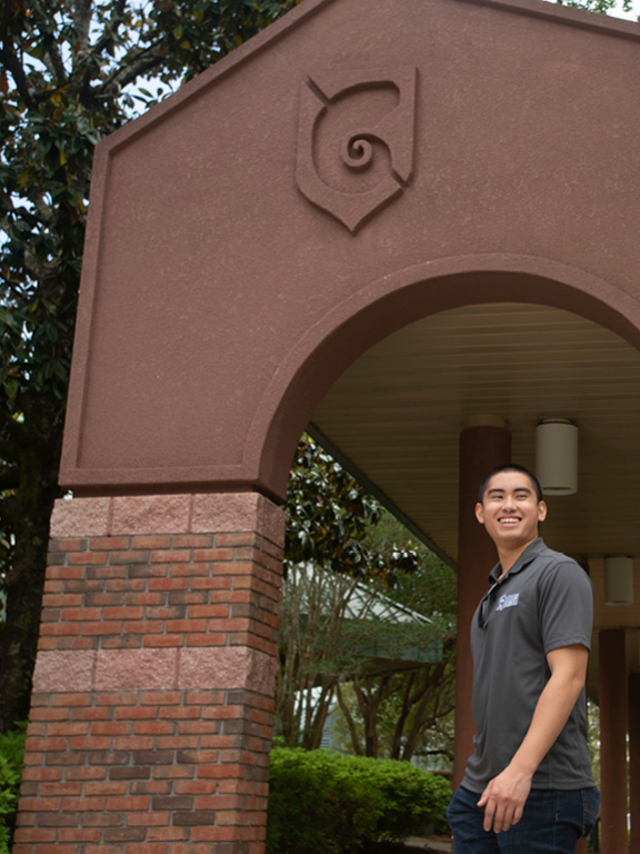 UWF Student in front of Nautilus Arch walkway