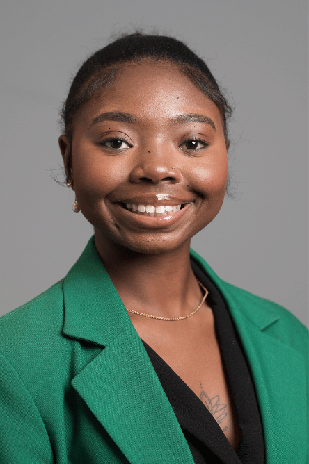Headshot of a Student ambassador with a green jacket on