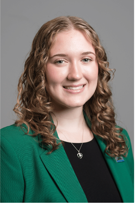 Headshot of a Student ambassador with a green jacket on
